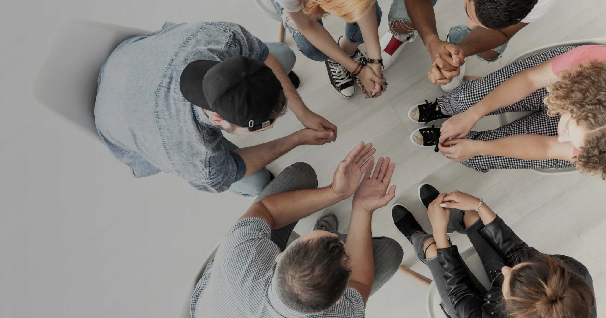 a group of youths are pictured from above taking part in a counselling session